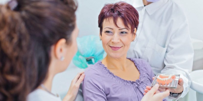 Patientin lässt sich über Zahnimplantate und Risiken aufklären.