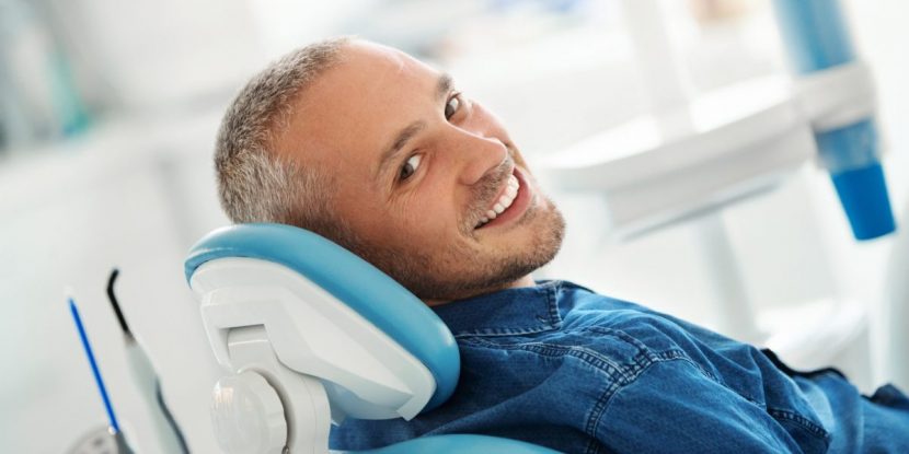 Mann hat Zahnkrone auf Zahnimplantat erhalten.